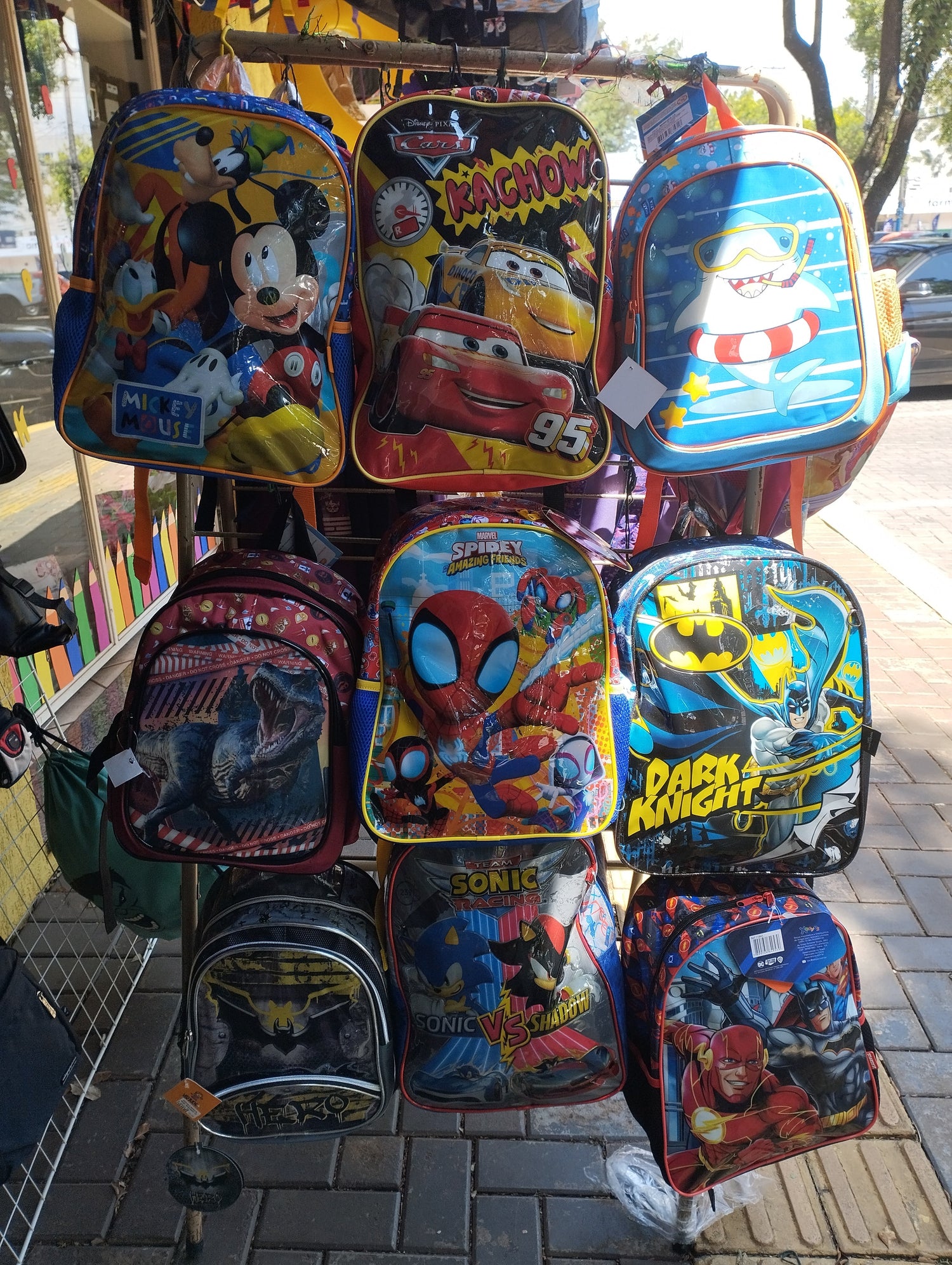 Expositor com mochilas infantis lindas com cores bem destacadas